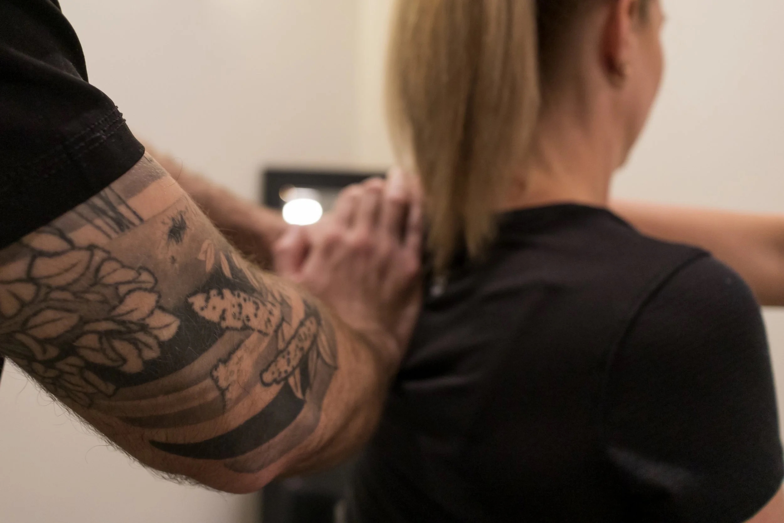 Therapist applying targeted manual pressure to a client's upper back during RAPID NFR treatment at Flex Physio & Wellness